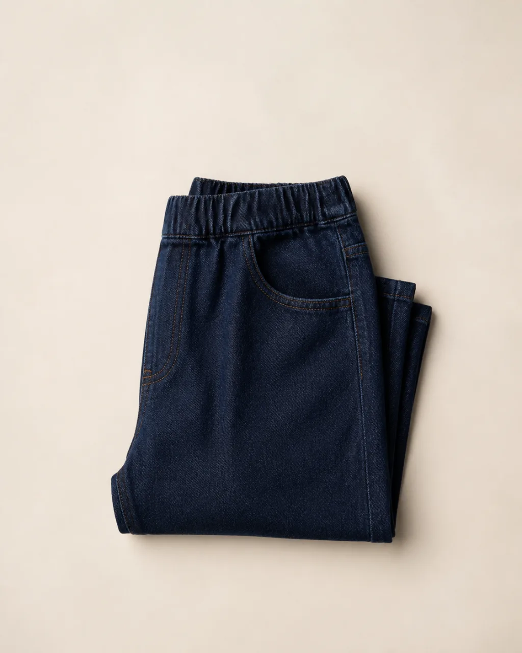 a folded, flat-laid pair of pull-on jeans with a high rise