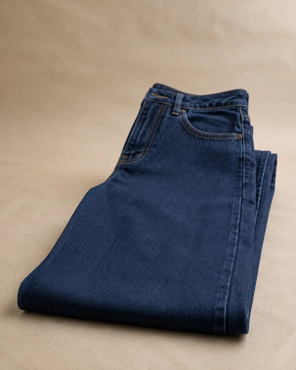 a folded, flat-laid pair of stretch jeans with a super-high rise