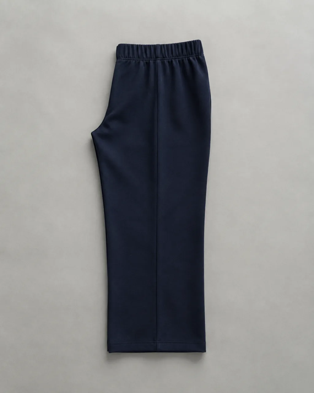 a pair of ponte knit pants folded in half lengthwise, side seam running down the frame with a high rise and a full elastic waistband , fabric: Ponte knit